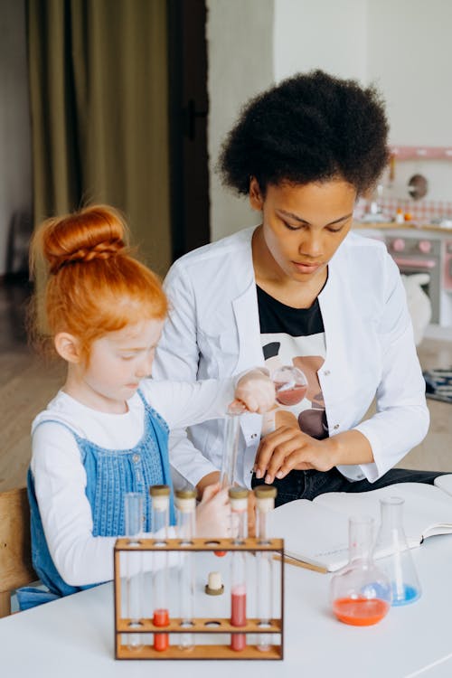 A Woman and a Girl Doing a Chemistry Experiment 