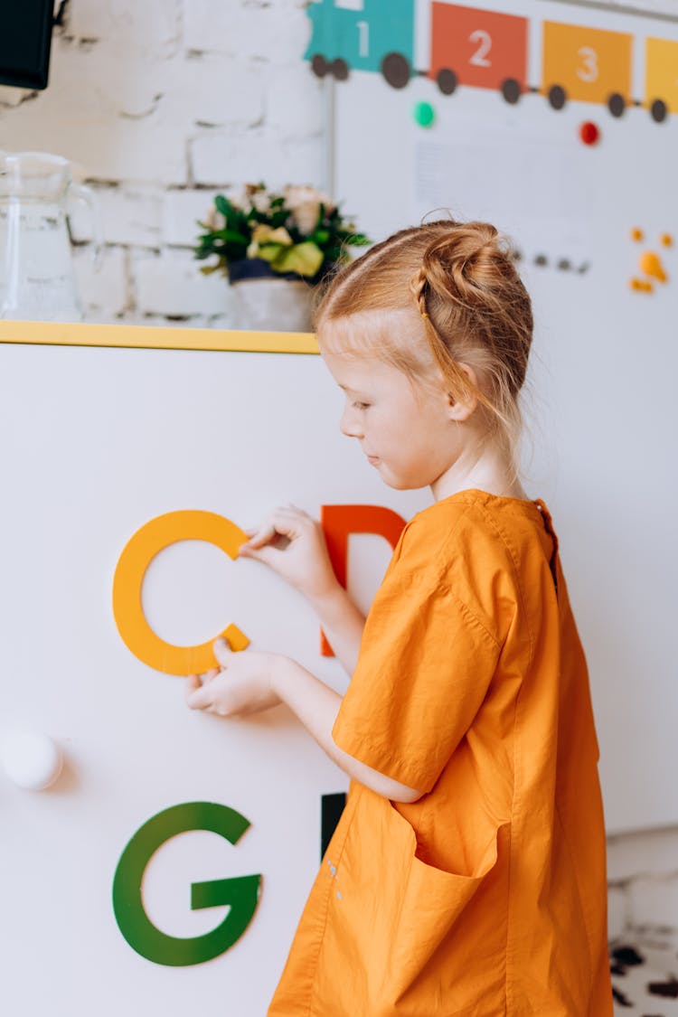 A Young Girl Holding A Letter C