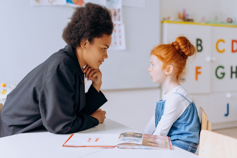 Teacher and young student talking during a learning session