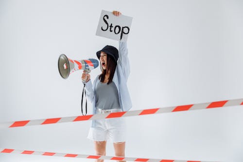 Free Person Holding Megaphone While Holding a Placard Stock Photo