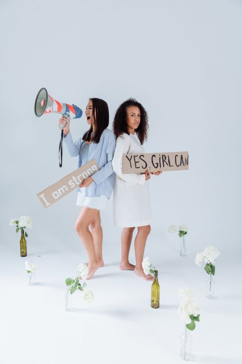 Free Two women with protest signs and flowers, symbolizing empowerment and activism. Stock Photo
