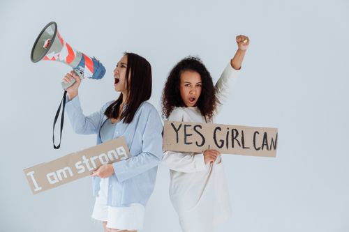 Free Two women expressing empowerment with signs and megaphone, advocating for feminism. Stock Photo