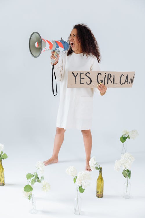 Free A Woman in White Dress Shouting while Holding a Megaphone Stock Photo