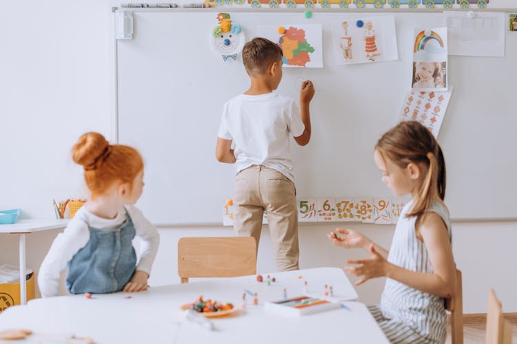 A Boy Writing On The Whiteboard 