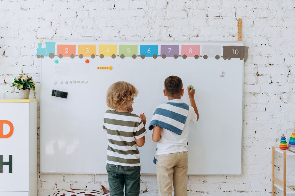 Photo by Mikhail Nilov on Pexels Two boys writing on a colorful classroom whiteboard, enhancing learning. - Photo by Mikhail Nilov on Pexels