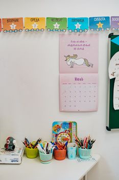 Vibrant classroom scene with art supplies against a colorful calendar wall.