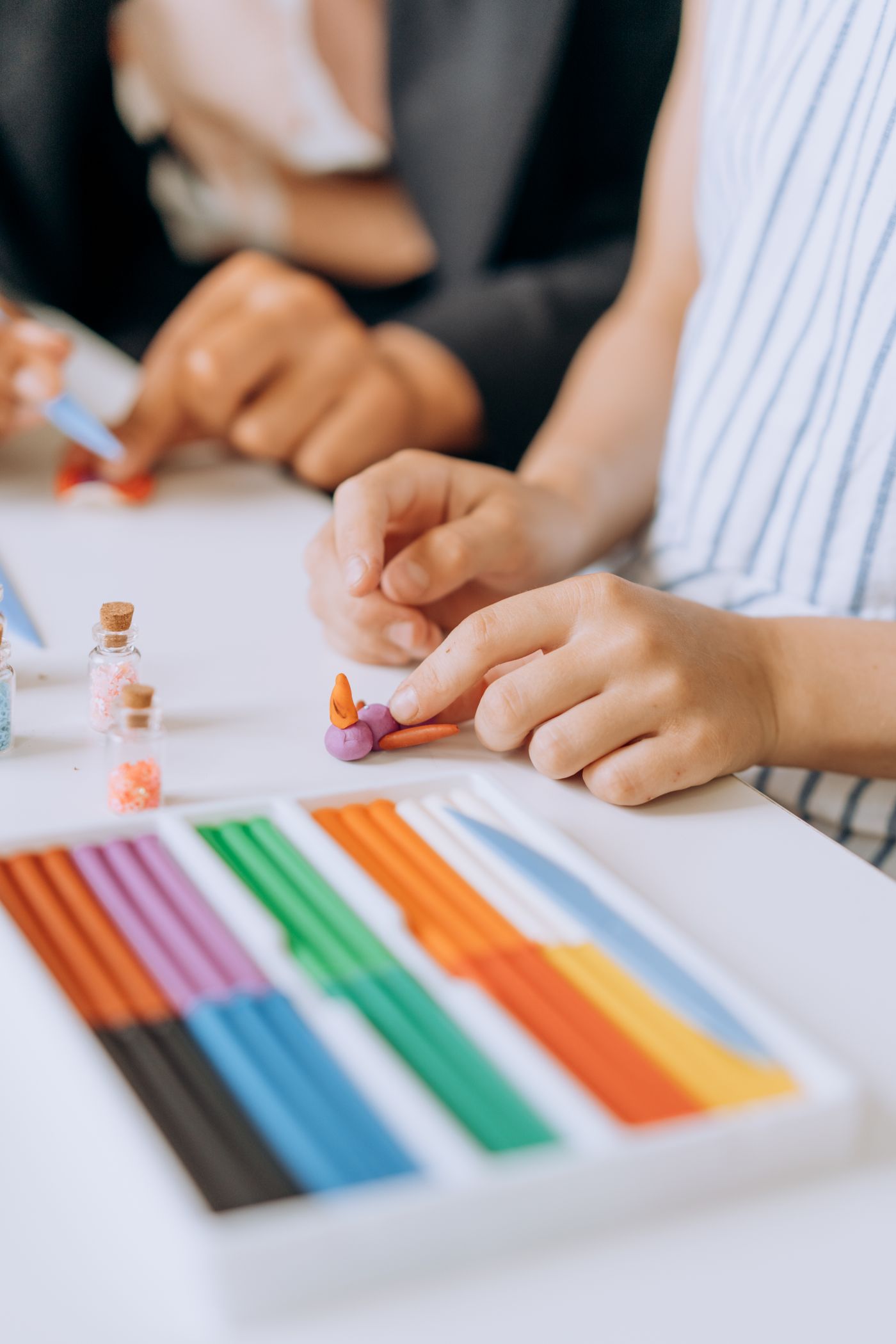 Hands crafting with colorful plasticine clay