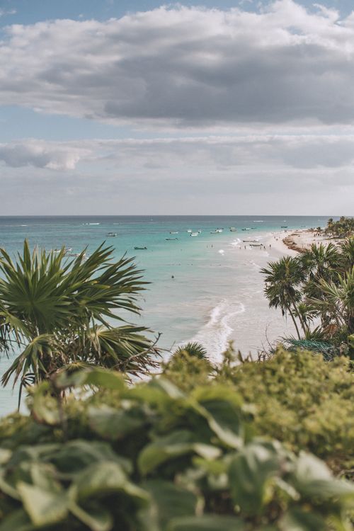 Free Explore the picturesque beach in Tulum, Mexico with lush greenery and turquoise waters under a cloudy sky. Stock Photo