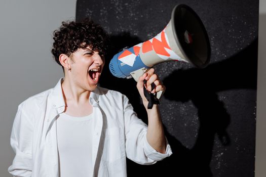 A man passionately shouting through a decorated megaphone, symbolizing activism.