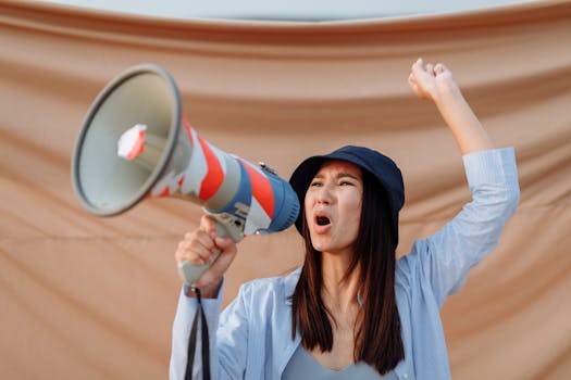 Woman passionately protesting with loudspeaker, expressing activism outdoors.