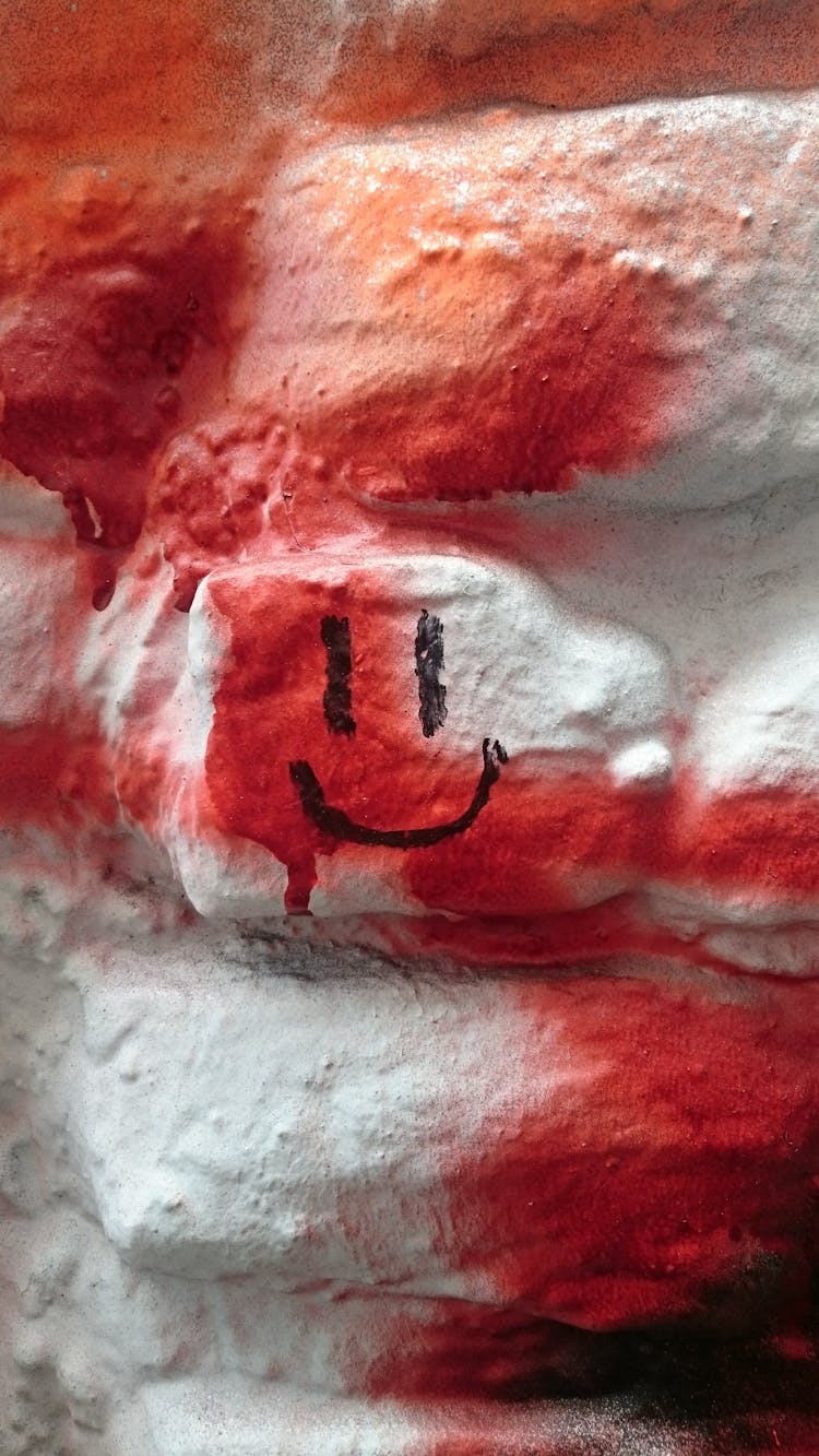 A White And Red Painted Wall With A Smiley Drawing