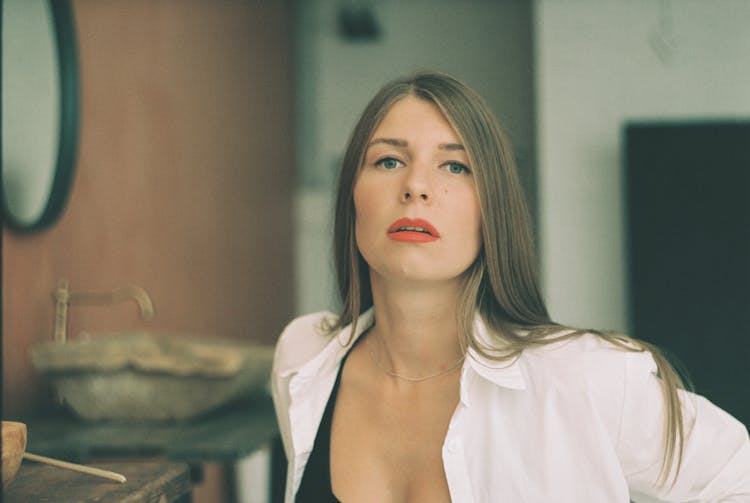 A Pretty Woman In White Button Up Shirt With A Long Straight Hair