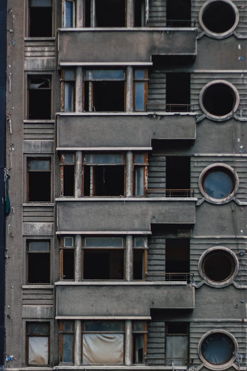 An Abandoned Apartment Building with Balconies and Round Windows