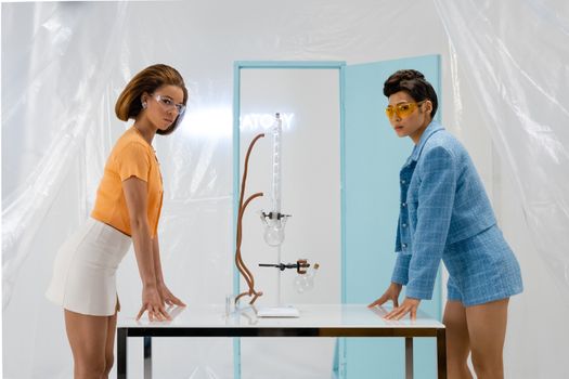 Two fashionable women in a lab posing with experimental equipment in a modern setting.