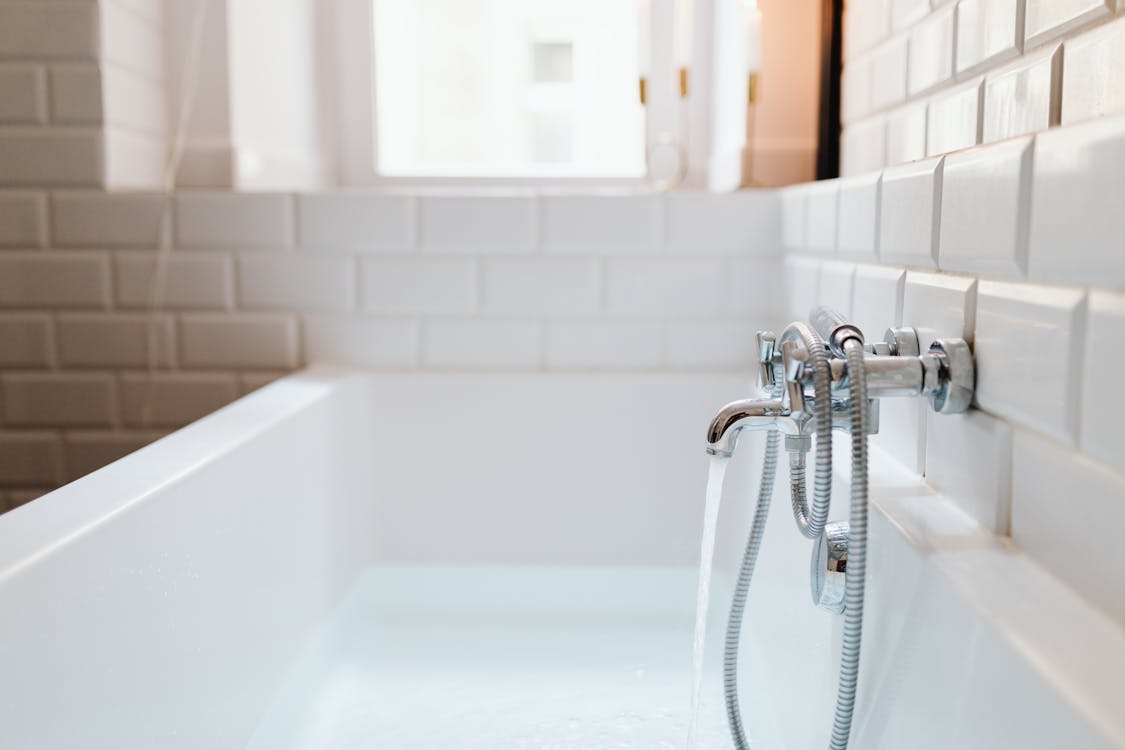 Free Stainless Steel Faucet Mounted on Ceramic Tiles Stock Photo