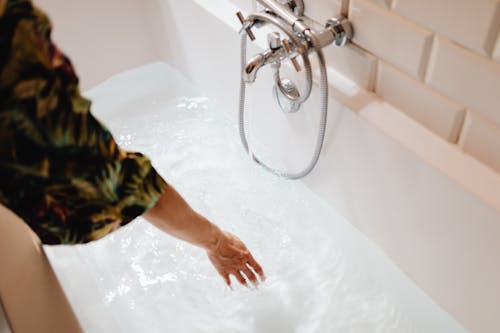 Free Close-Up Shot of a Person Touching a Water in a Bathtub Stock Photo