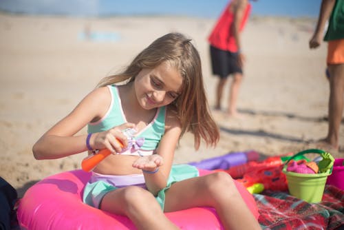 Free Young Girl Putting Sunscreen Lotion Stock Photo