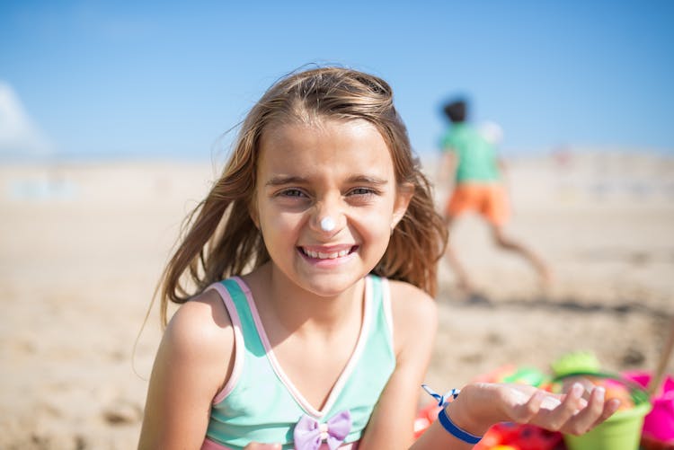 Young Girl In Swimwear Putting Sunscreen