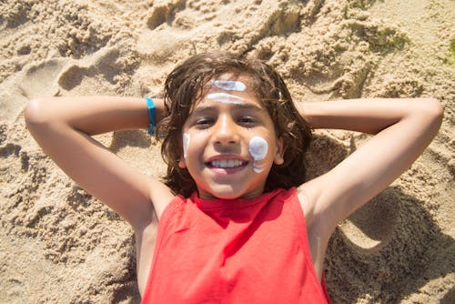 Free Young Boy Lying on Sand Stock Photo