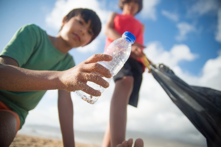 A Boy Holding An Empty Plastic Water Bottle