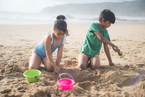 Free Kids digging sand and enjoying summer fun on a Portuguese beach. Stock Photo