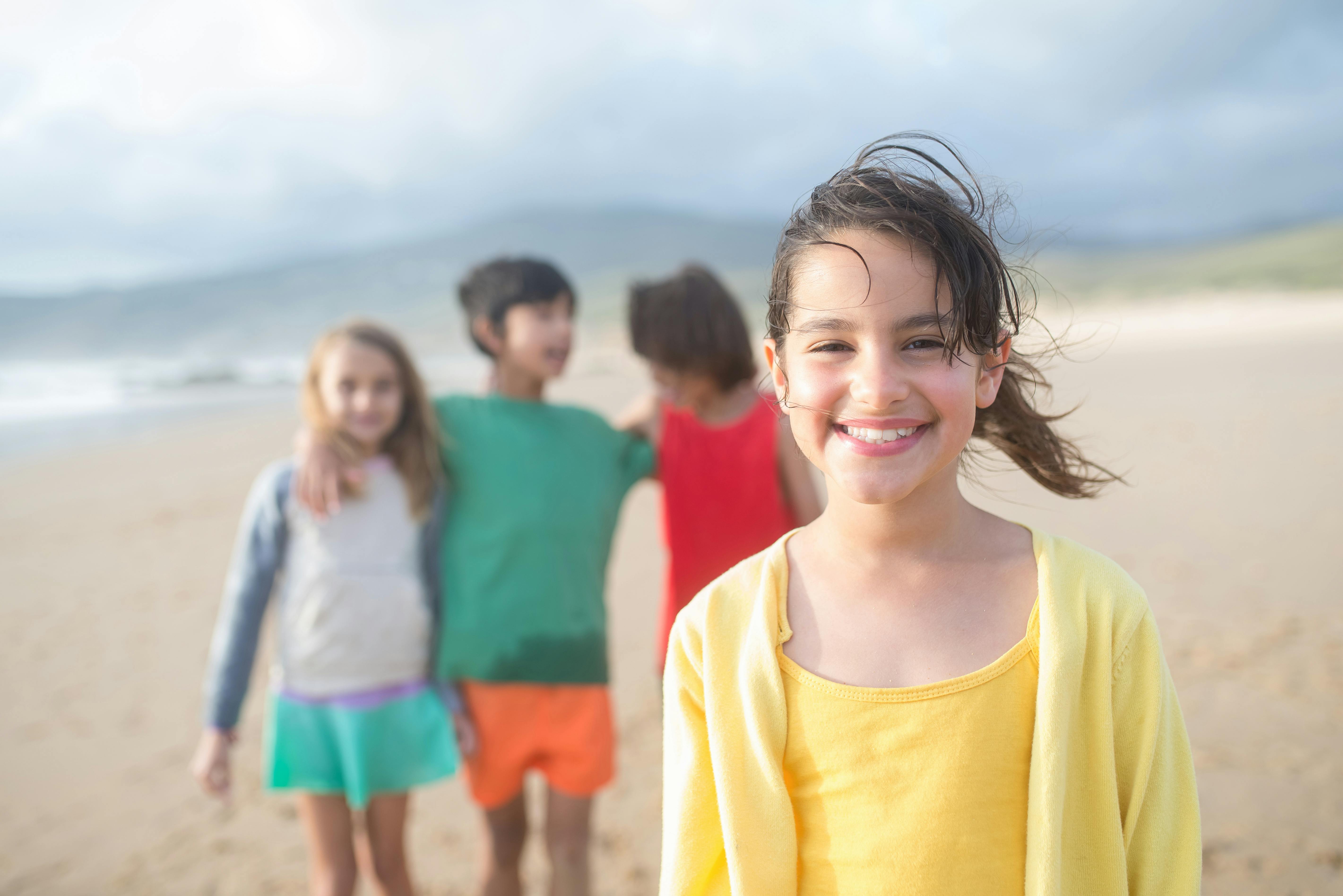 a girl in a yellow outfit at a beach