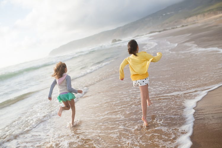 Photograph Of Two Kids Running At The Beach