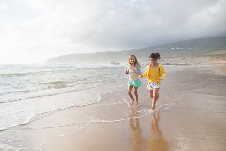 Little Girls Running Together On The Shore