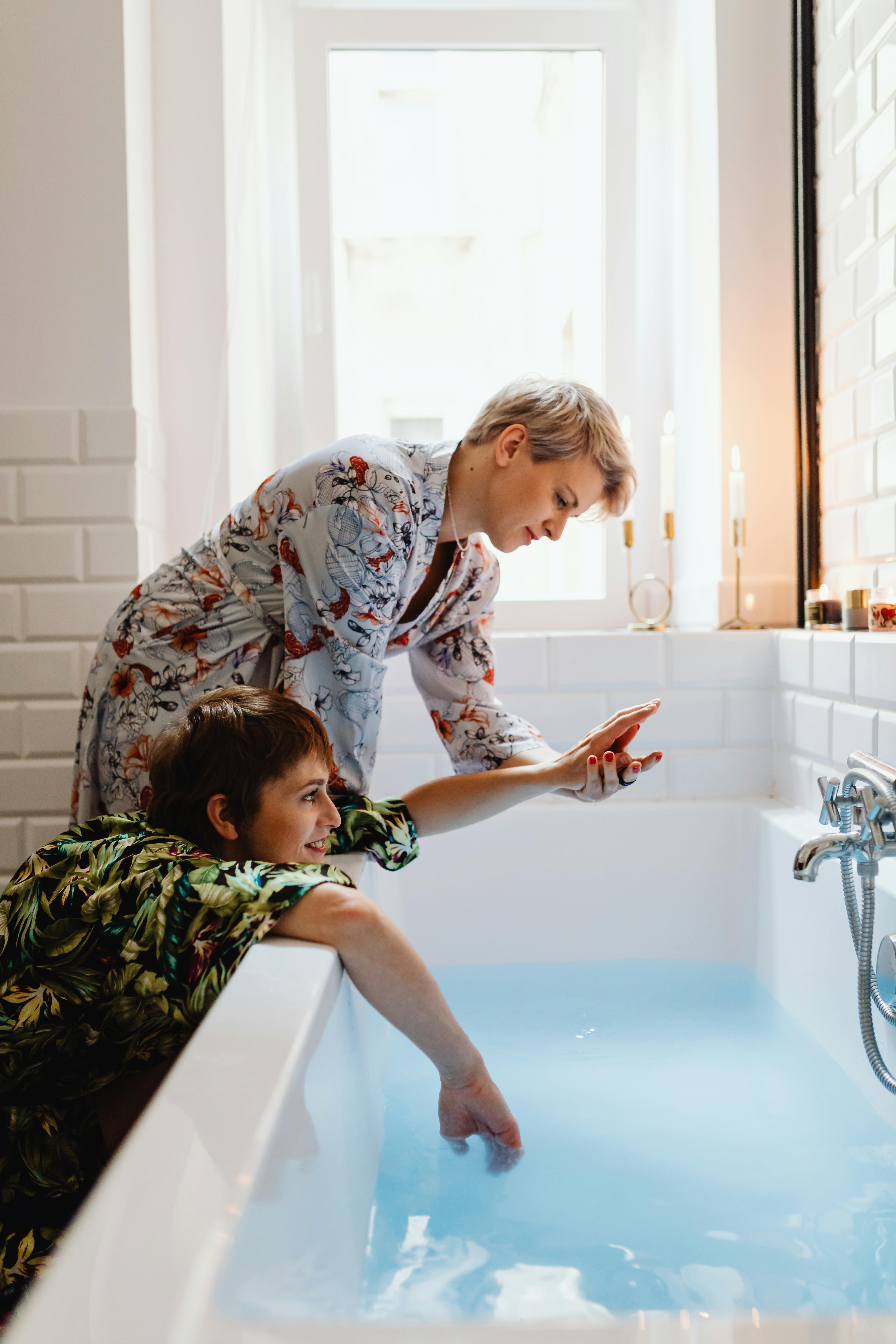 A Same Sex Couple Holding Hands Inside the Bathroom · Free Stock Photo