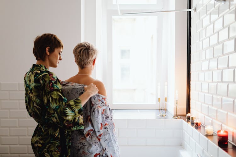 A Woman Removing Another Woman's Robe