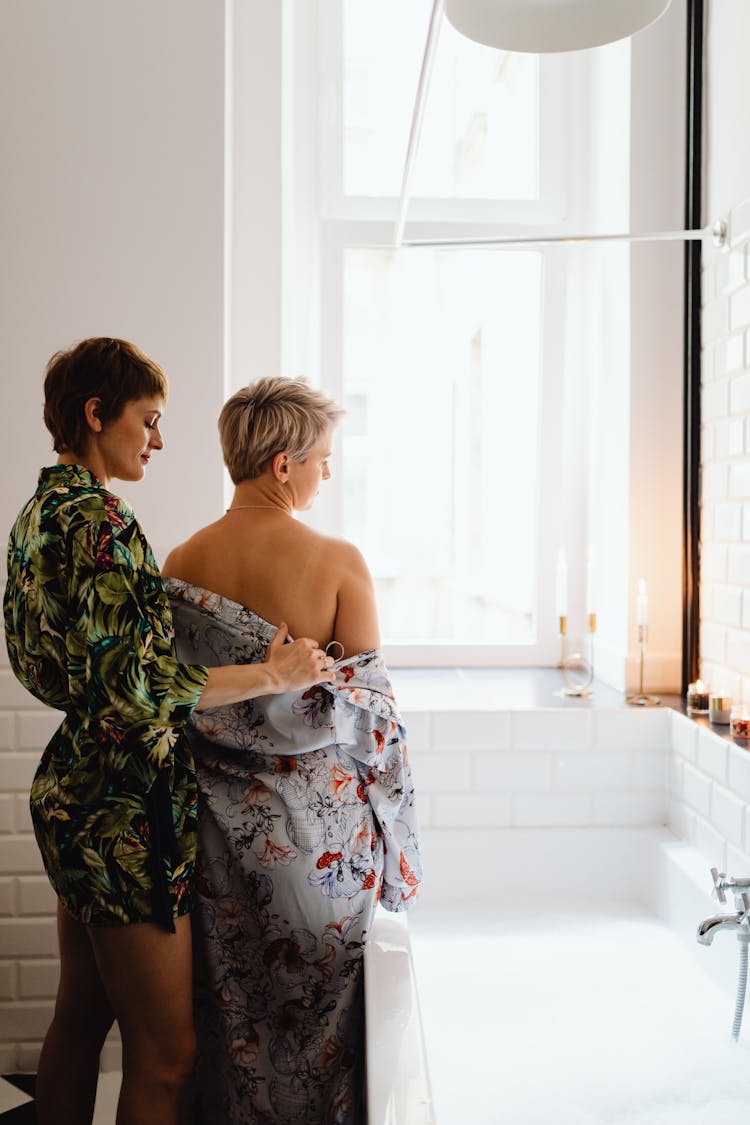 A Woman Removing Another Woman's Robe