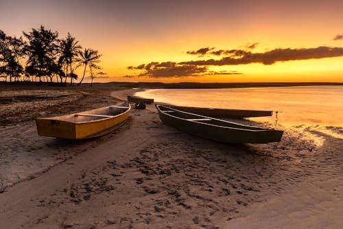 Photo of Wooden Boats on the Sand During Sunset