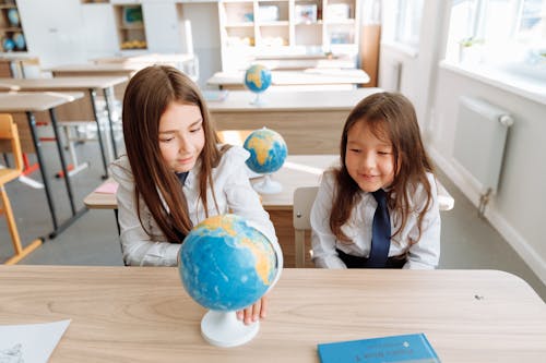 Free Two Girls Studying a Globe Stock Photo