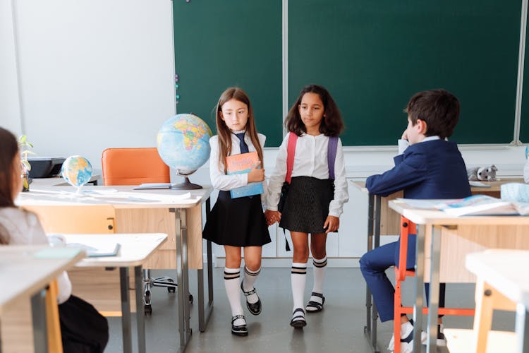 Two Girls Walking Inside The Classroom