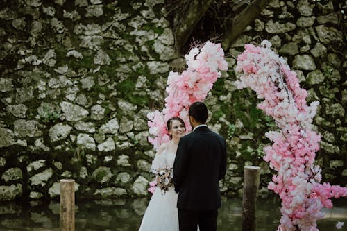 Free Photo of a Man and a Woman Getting Married Near a Flower Arch Stock Photo
