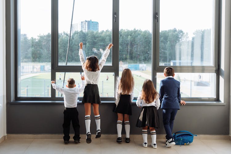 Back View Of Students In School Uniform Looking Outside