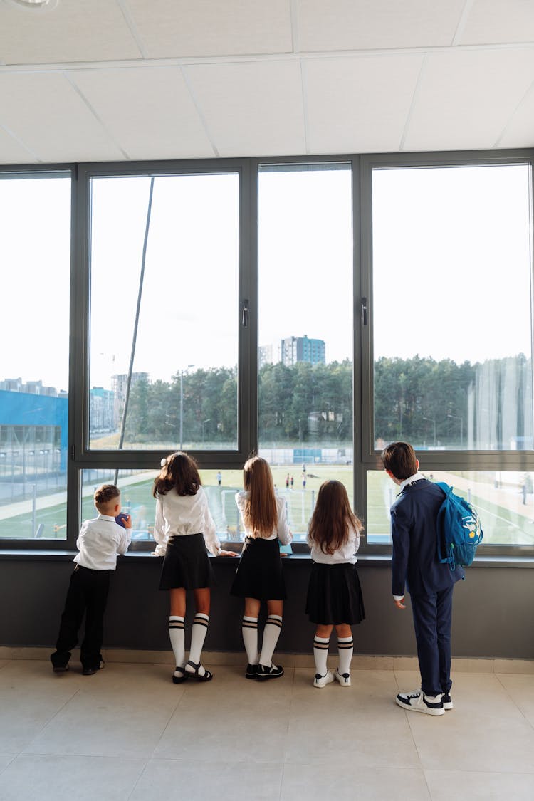 Back View Of Students In School Uniform Looking Outside