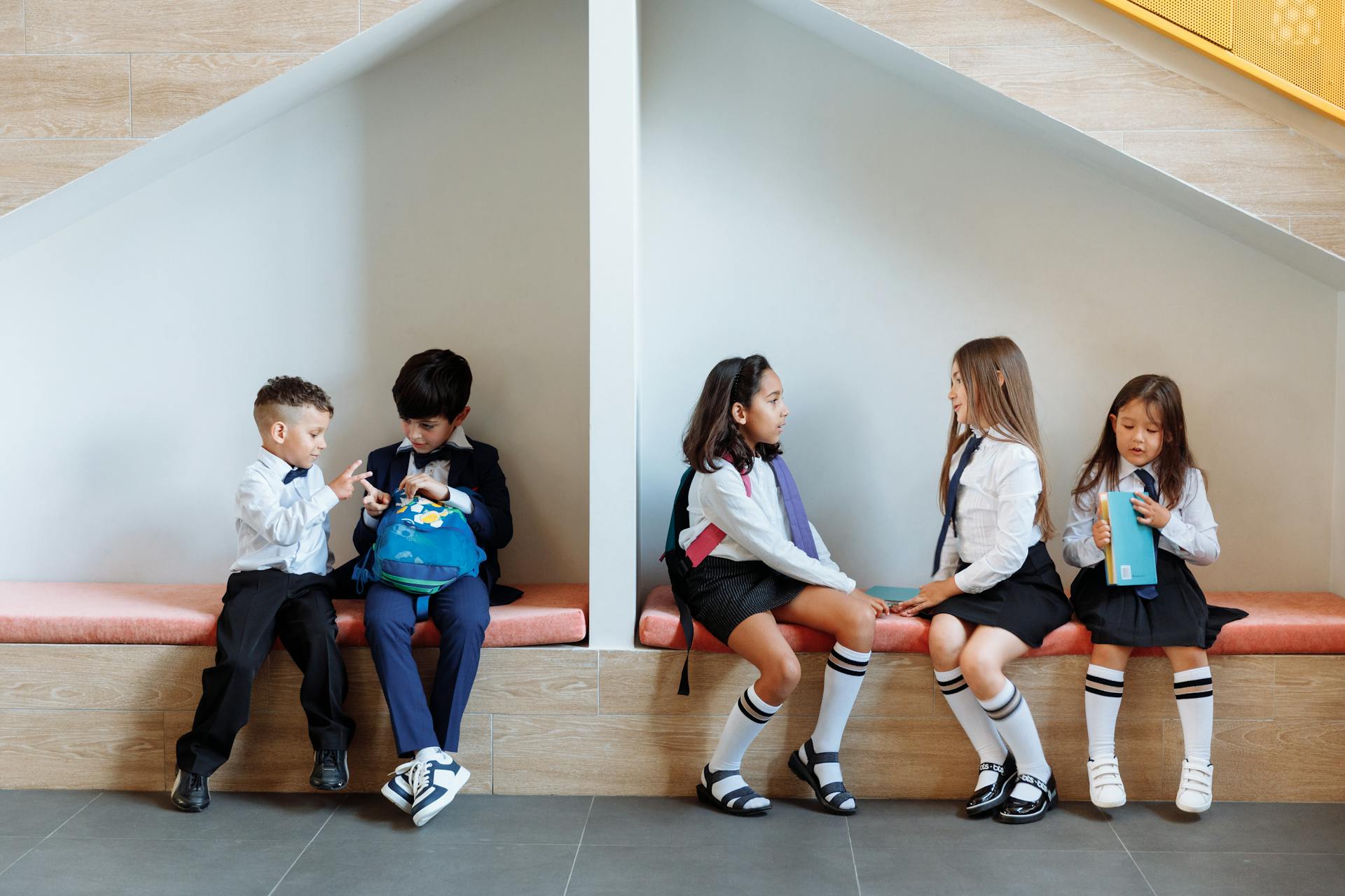 Students Sitting on the Bench while Talking to Each Other