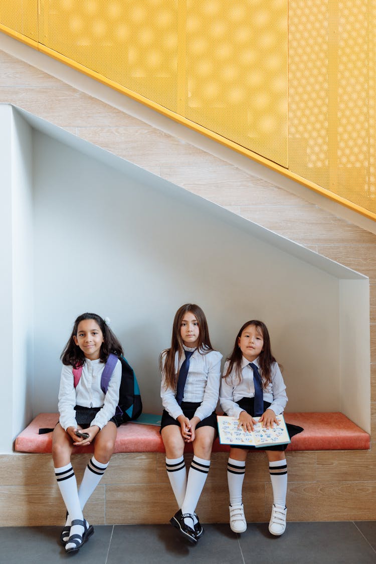 Three Girls In School Uniform Sitting On The Bench