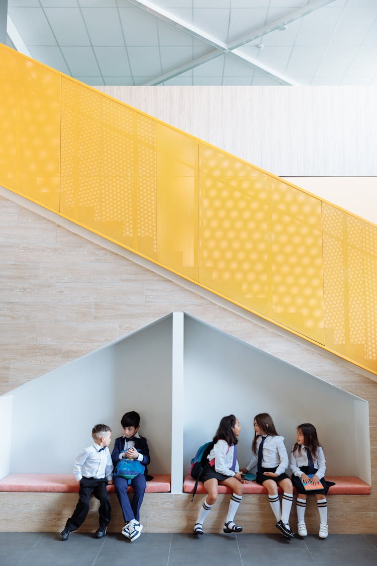 Students Sitting On The Bench While Talking To Each Other