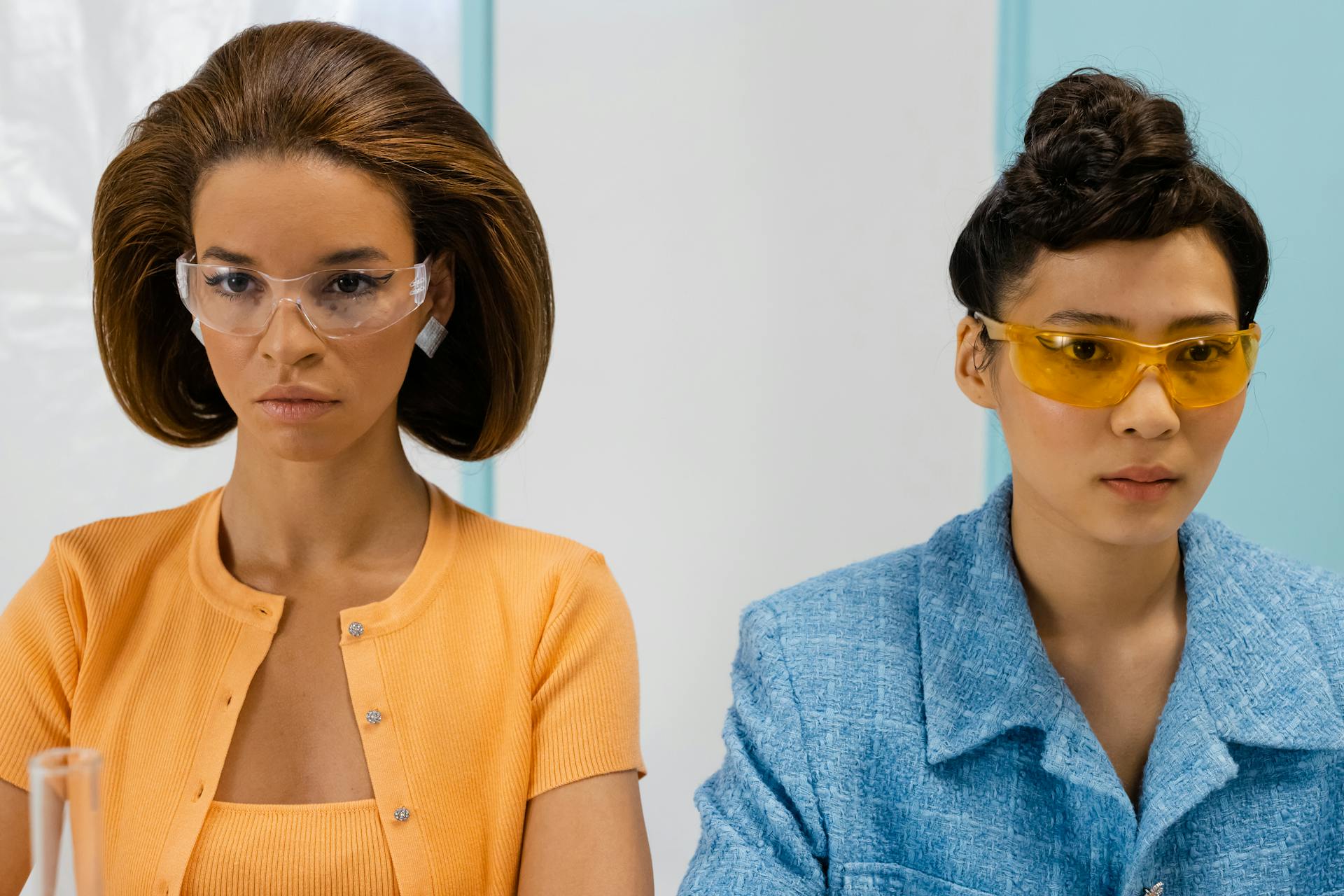 Two women scientists wearing protective goggles working in a laboratory.