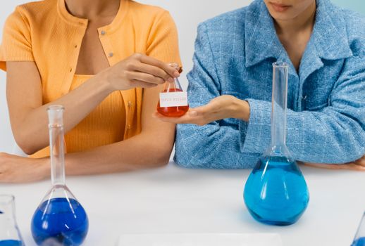 Woman Giving a Beaker with the Covid Killer to a Friend