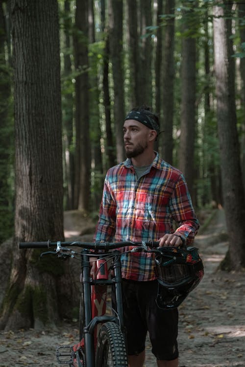 Photo of a Man in a Plaid Shirt Holding His Bicycle