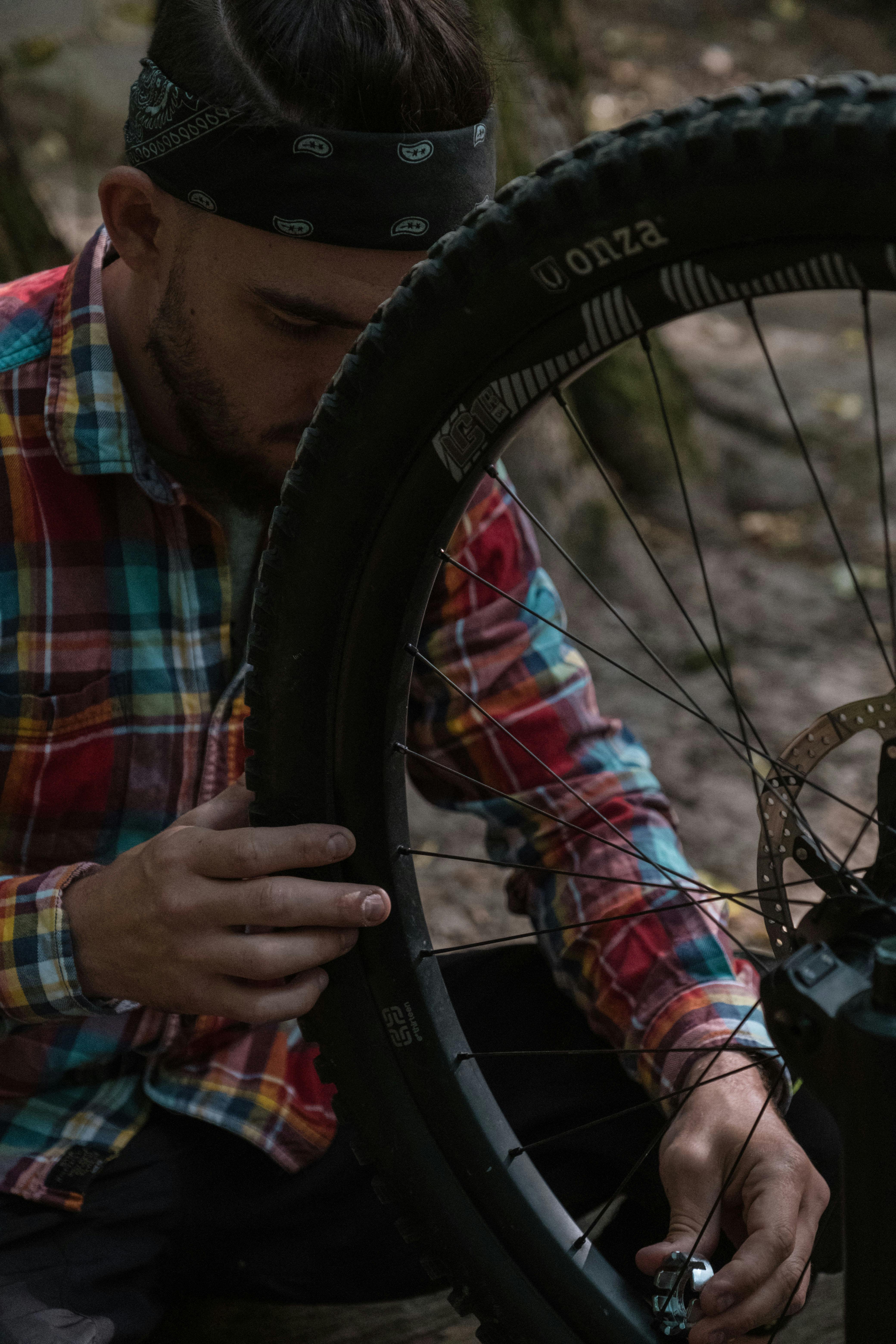 man fixing the tire of his bike