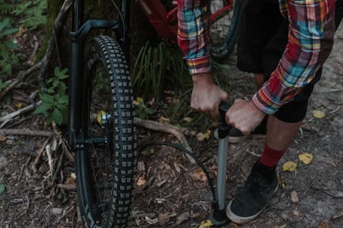 A Man Pumping Air into the Bike Tire