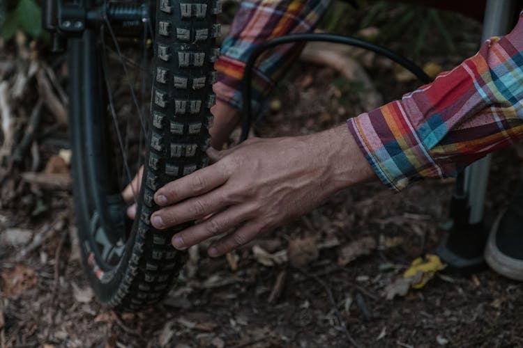 A Person Inflating A Tire On A Bicycle