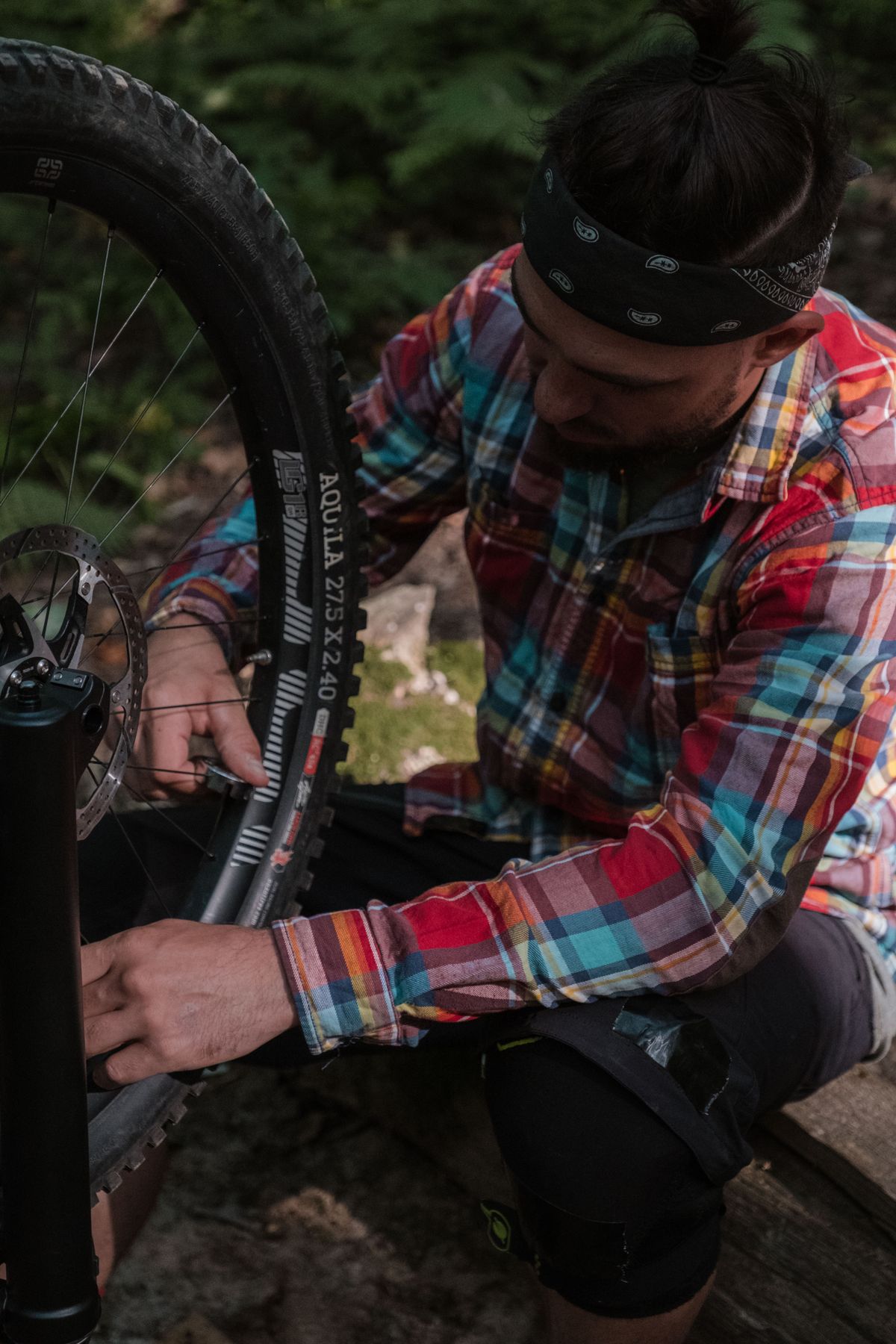 Cyclist carefully repairing a bicycle wheel outdoors