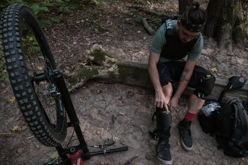 Man Putting On Protective Gear for Mountain Biking