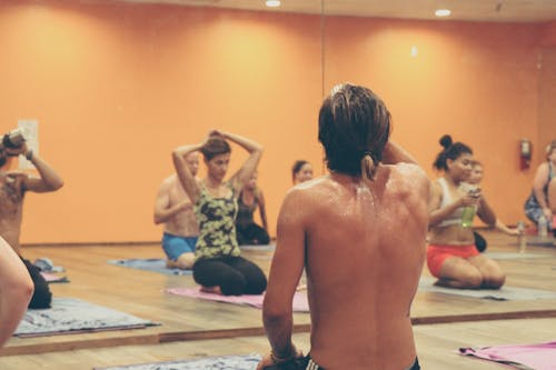 People Exercising Inside Brown Painted Room