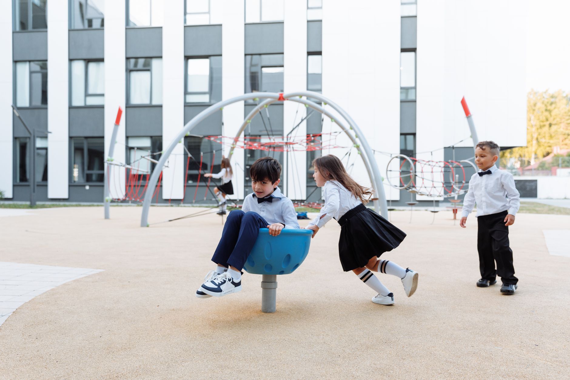 American school family day New Cairo — Joyful children having fun together in a modern outdoor playground area, dressed in fo